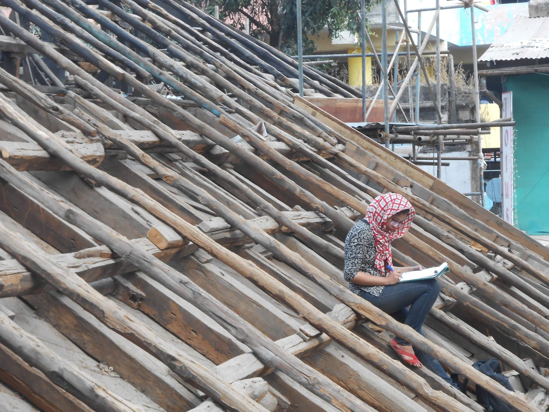 Manasi sketching during heritage documentation on a traditional timber roof